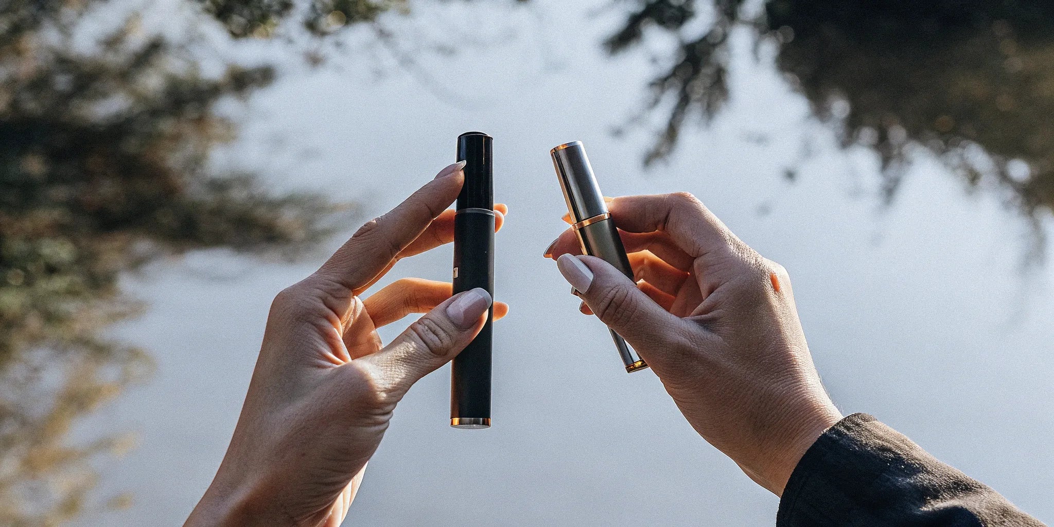 A person holds two dab pens, a device with known health effects.