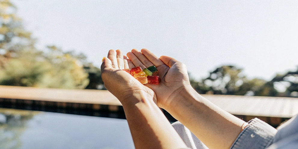 A person's hands holding a variety of colorful gummies for pain relief.