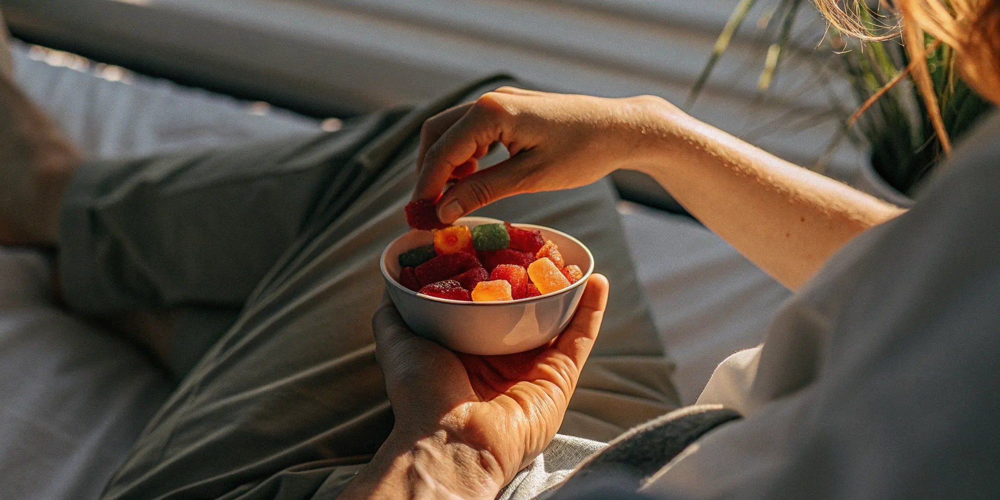 Hand holding a bowl of the best THC gummies for arousal.