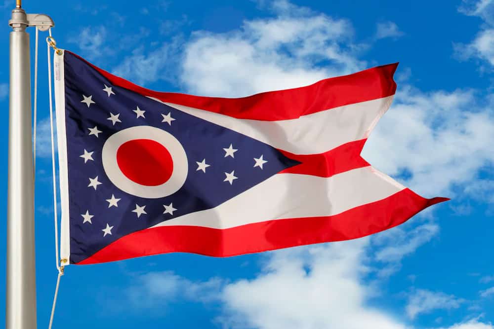 Ohio state flag waving against a blue sky