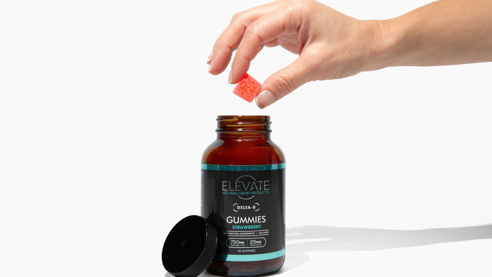 A hand holding a strawberry Delta 8 gummy above a jar labeled 'Delta 8 Gummies Strawberry' with 750mg total and 25mg per gummy.