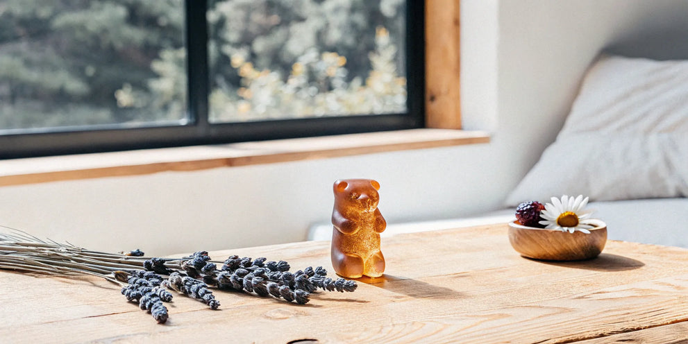 A mood gummy on a wooden table with sprigs of dried lavender.