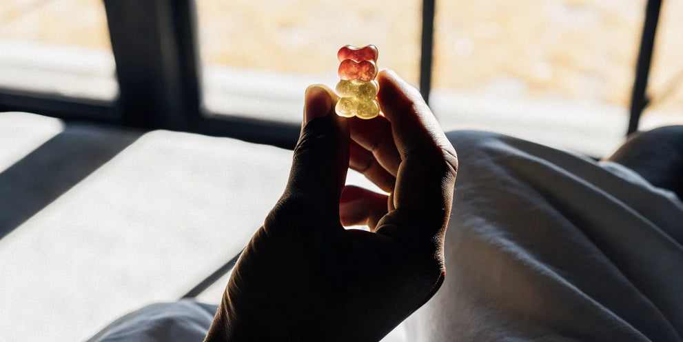 A close-up of a hand holding a THC gummy for libido.