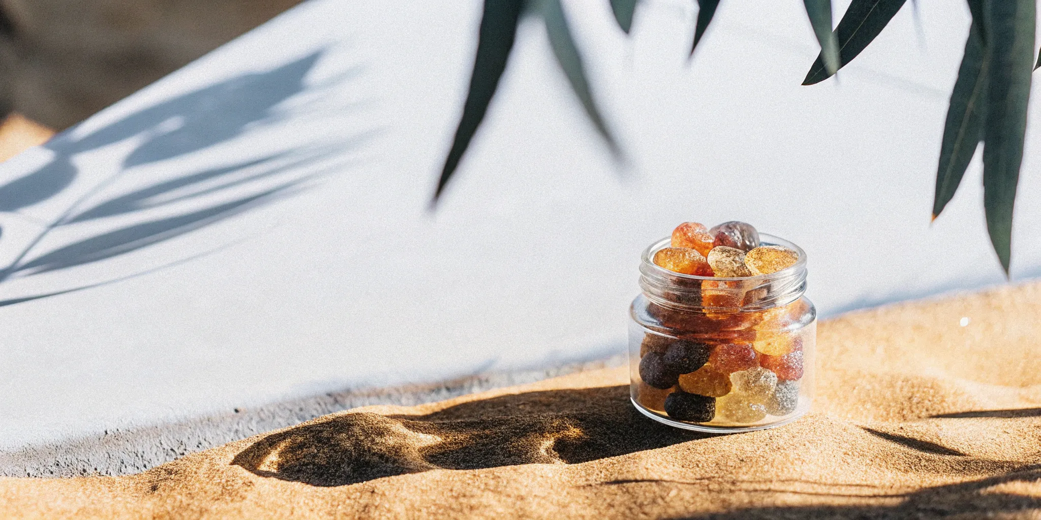 Delta 8 THC gummies jar on sand.